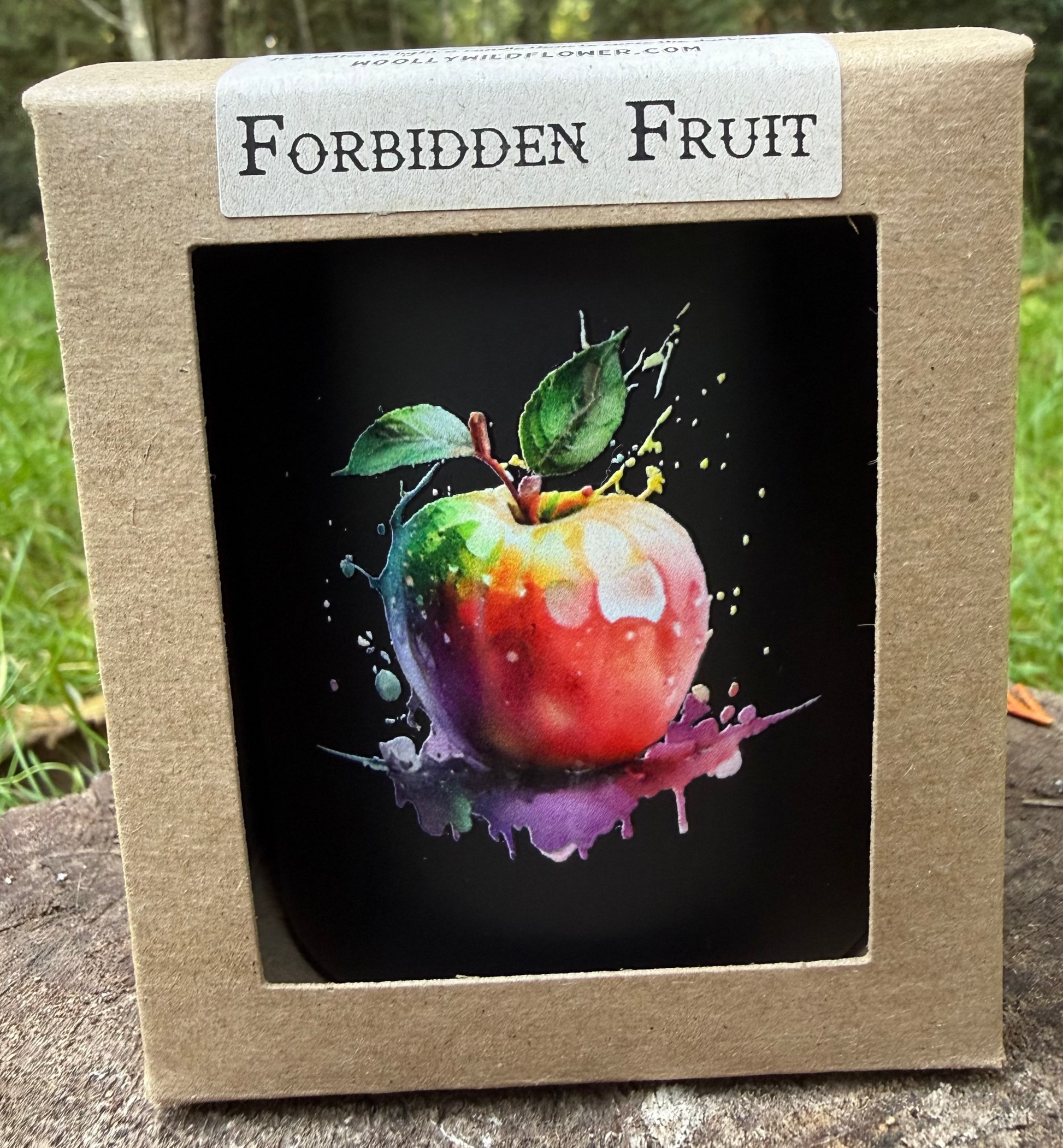 Box with a colorful apple illustration and 'Forbidden Fruit' label on a natural background