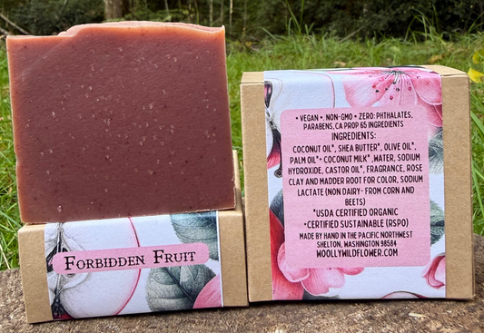 Bar of soap with packaging labeled 'Forbidden Fruit' against a natural background