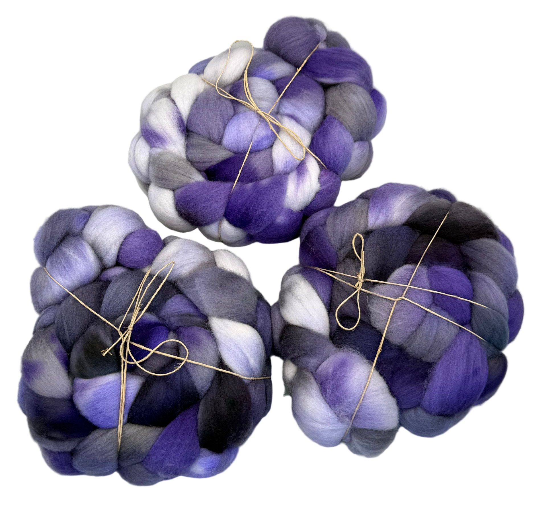 Three skeins of purple and white fibers on a light gray background