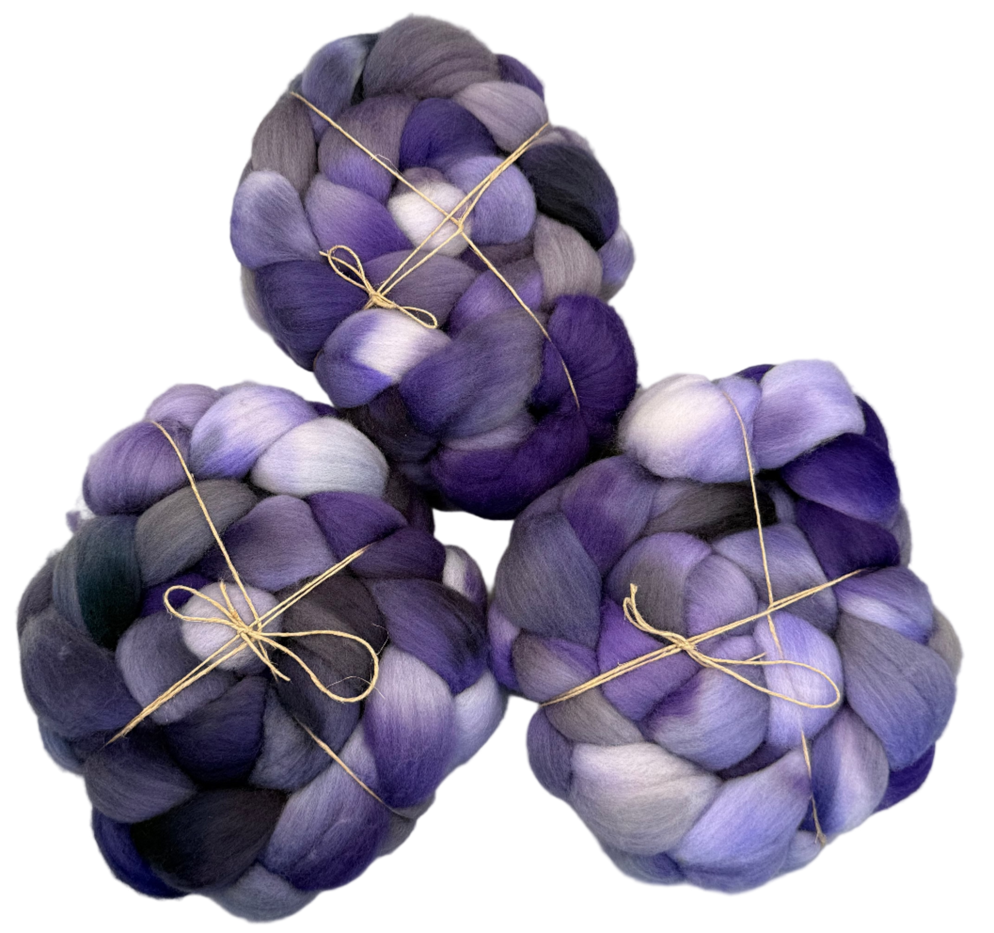 Three skeins of purple and gray fibers tied with twine on a light background