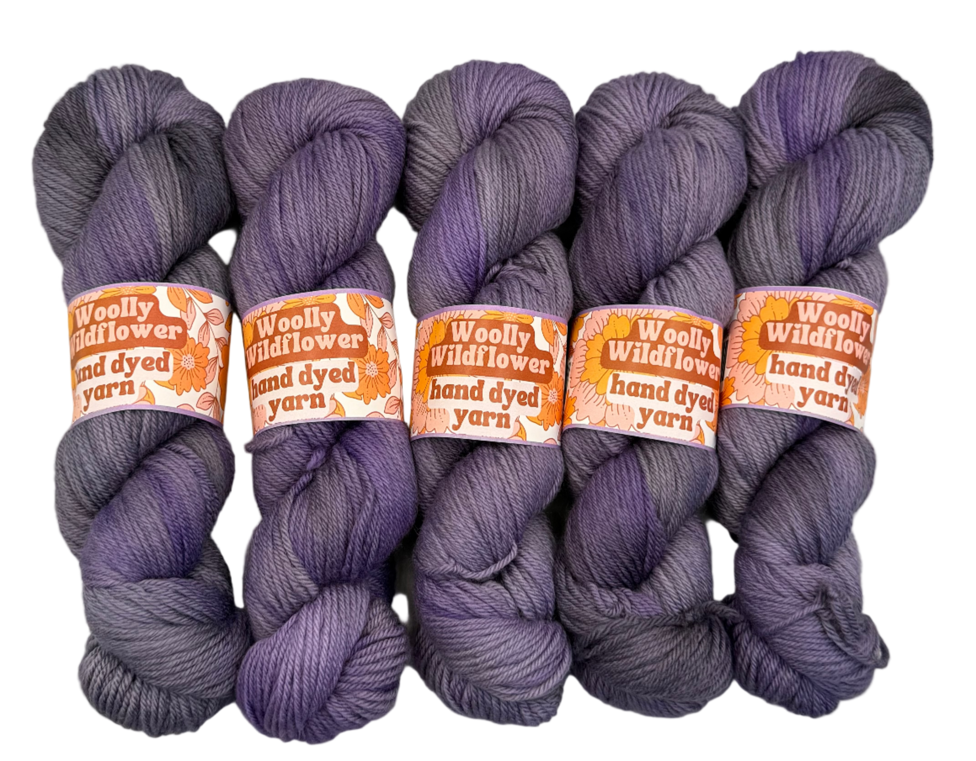 Five skeins of purple yarn with orange labels on a white background
