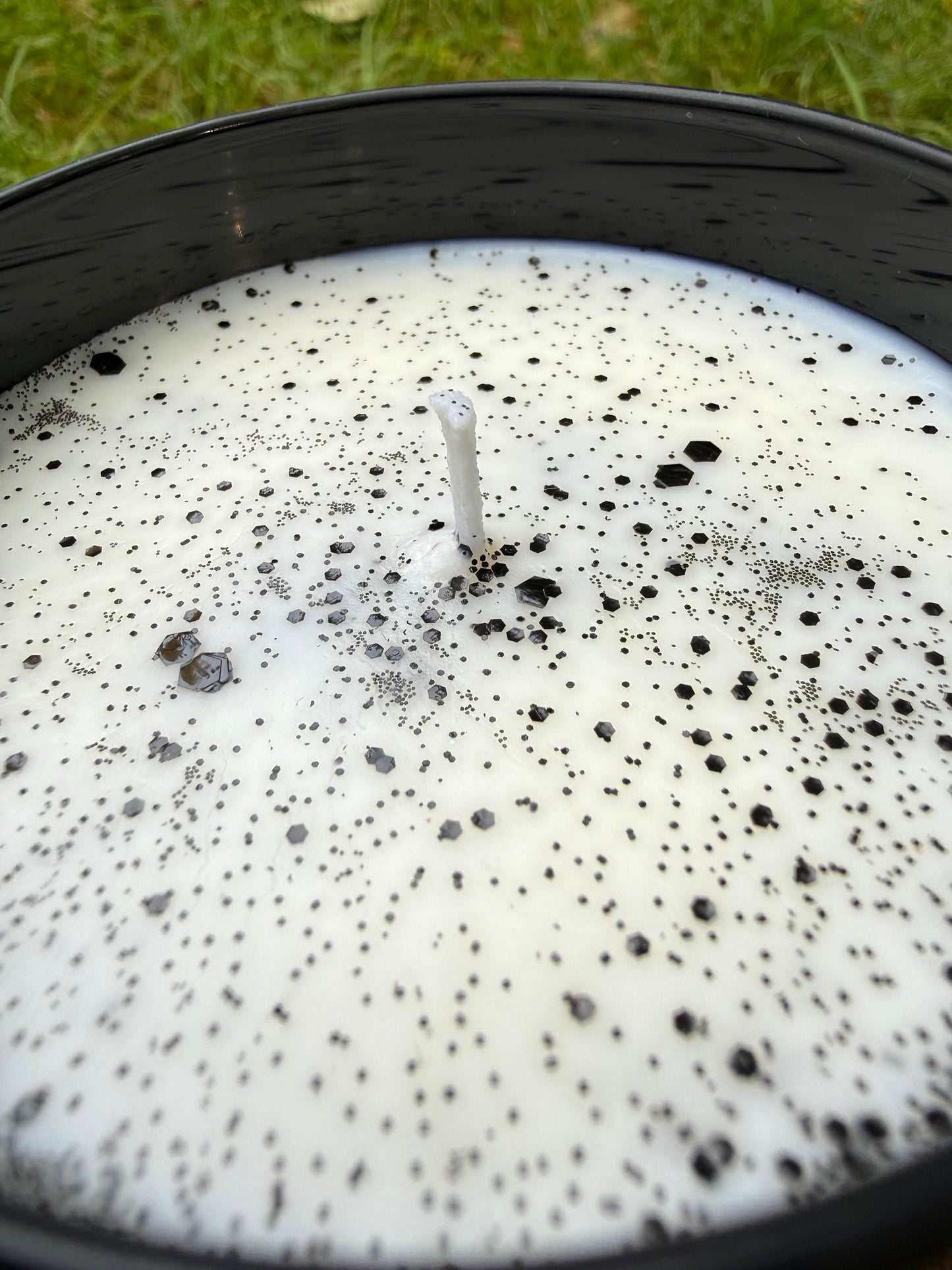 Close-up of a candle with black specks on a white background