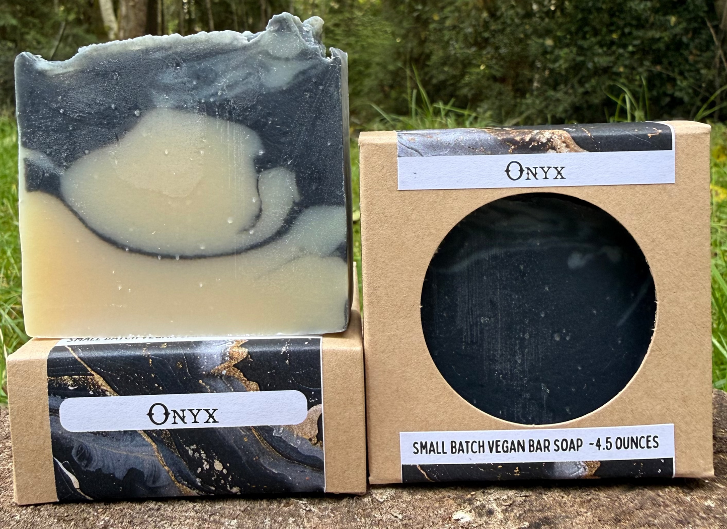 Onyx soap bar and packaging on a wooden surface with a forest background