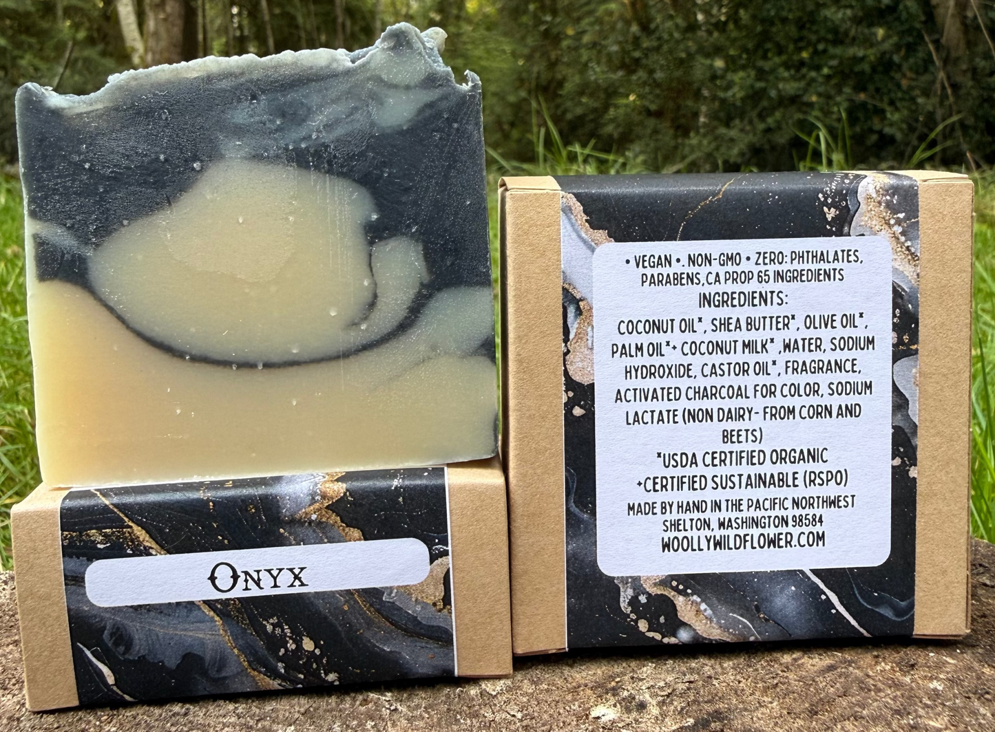 Two bars of soap with packaging on a wooden stump outdoors