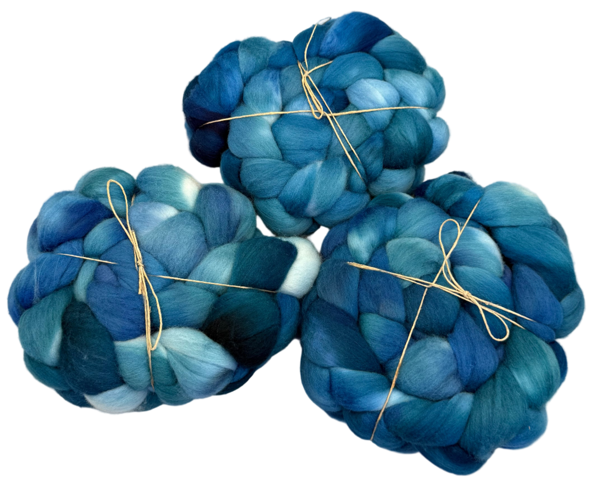 Three skeins of blues and greens fibers tied with twine on a light background