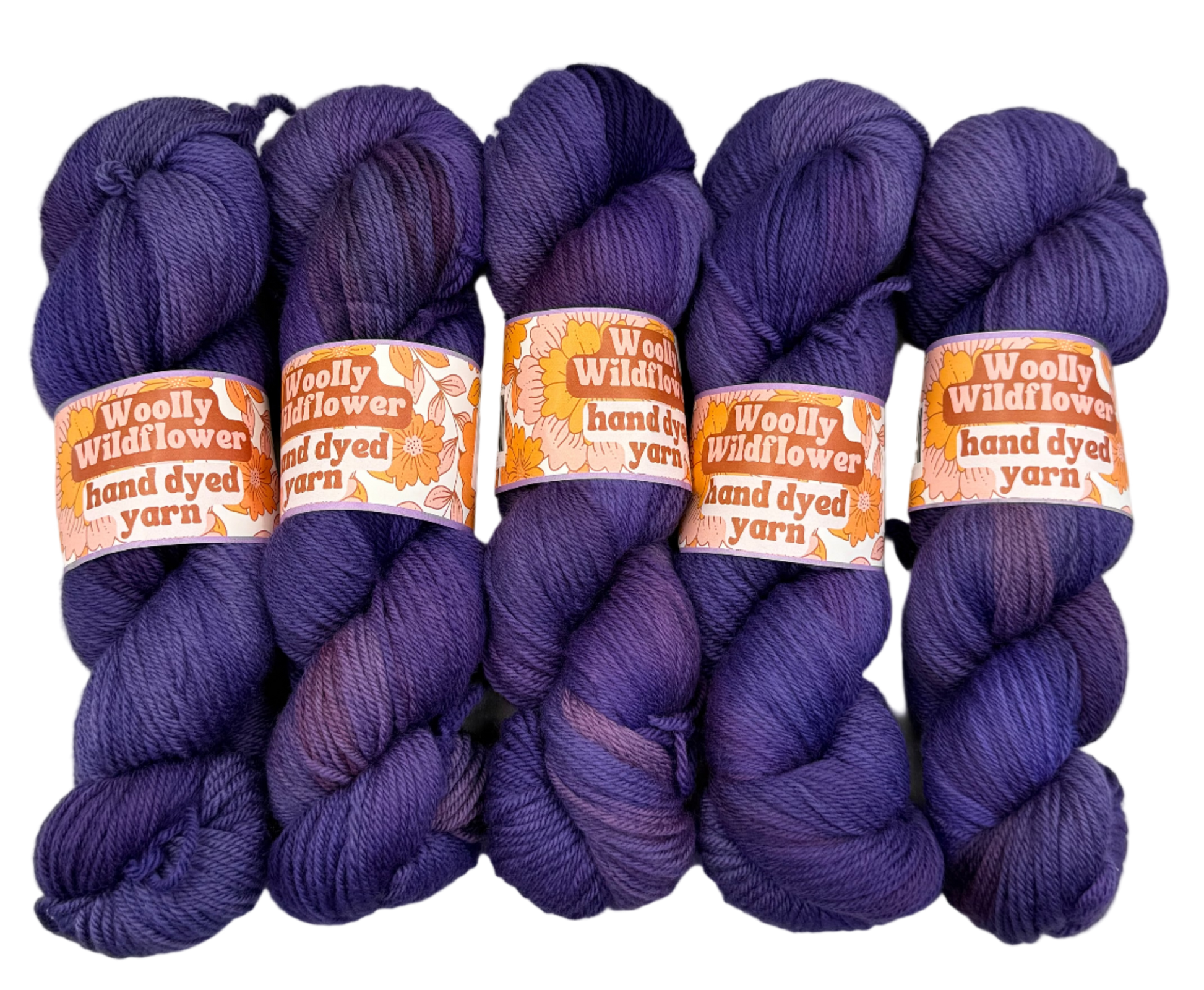 Four skeins of purple yarn with 'Woolly Wildflower' labels on a light gray background