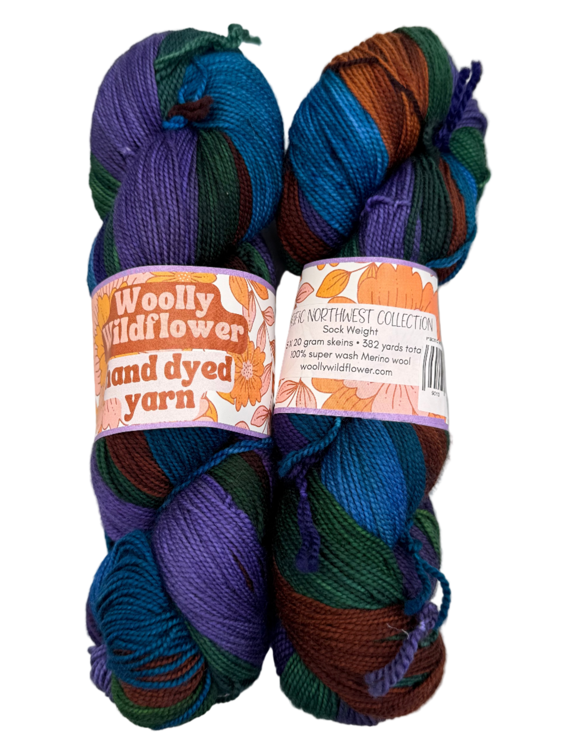 Two skeins of hand-dyed yarn with labels on a white background