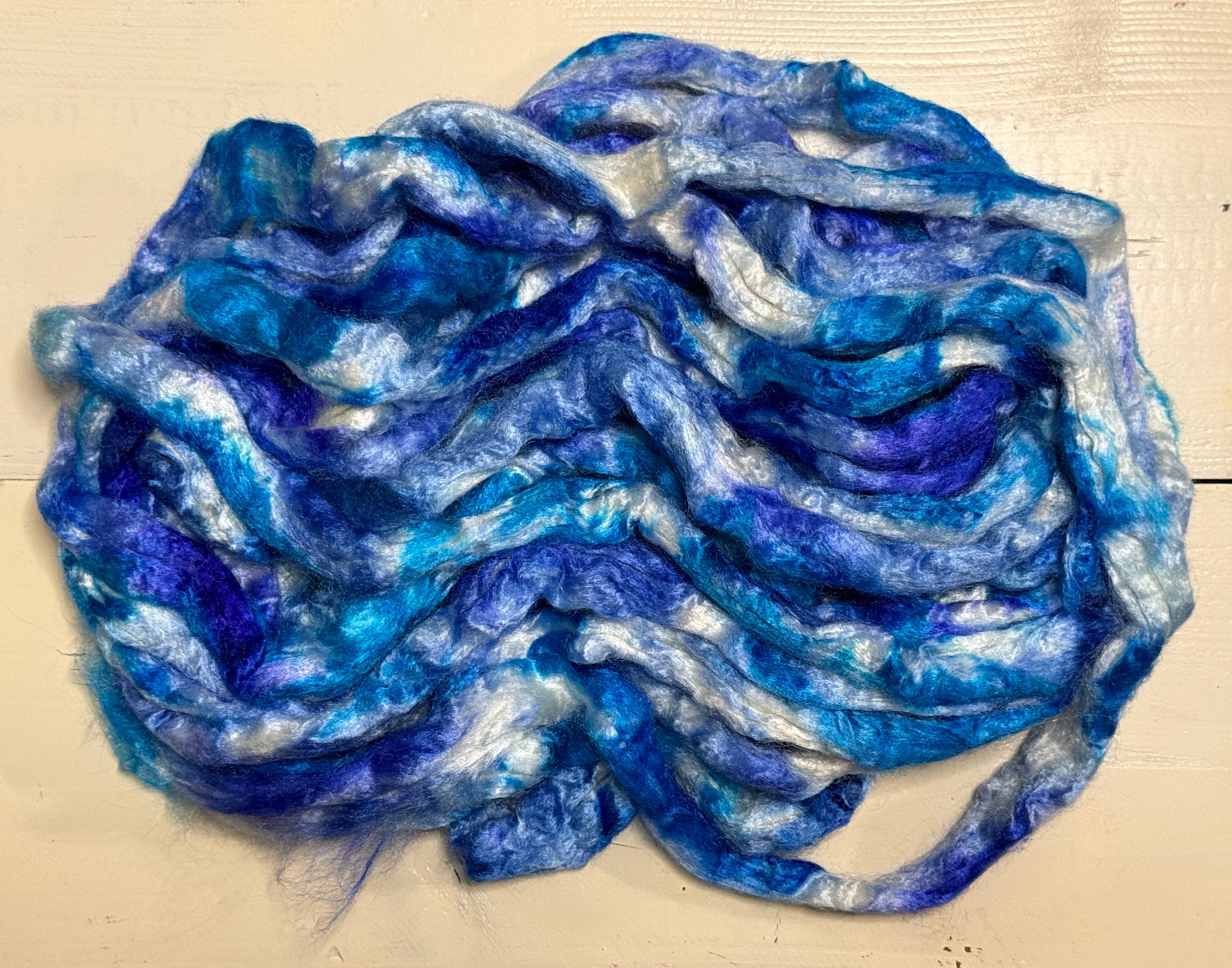 Blue and white fiber roving on a beige background