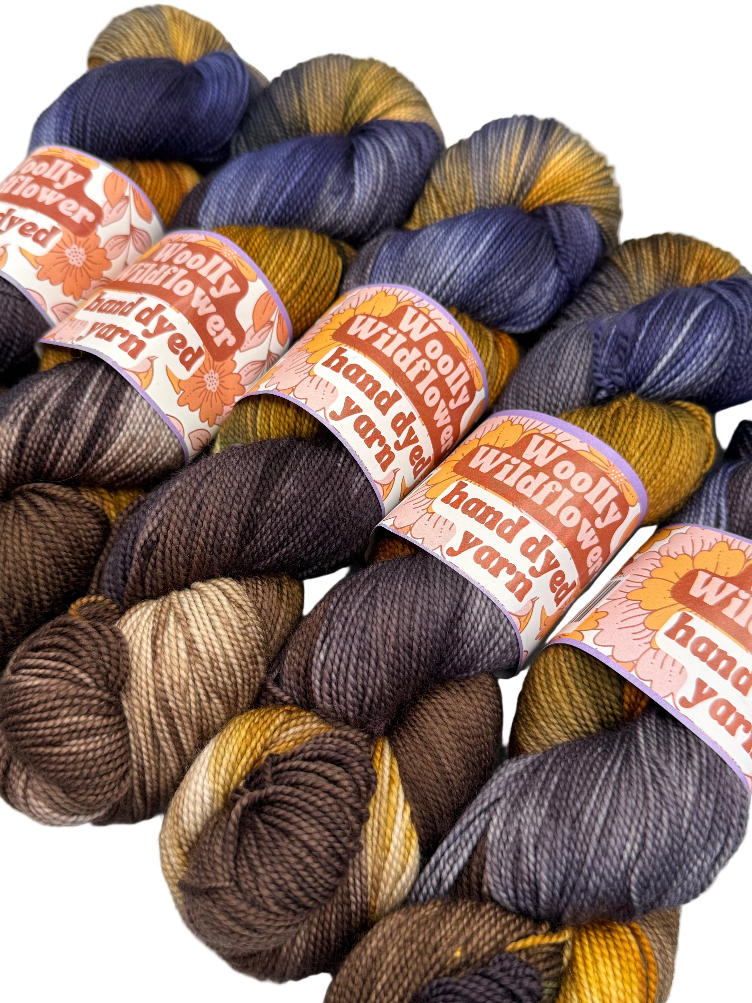 Woolly Wildflower hand-dyed yarn in various colors with labels.