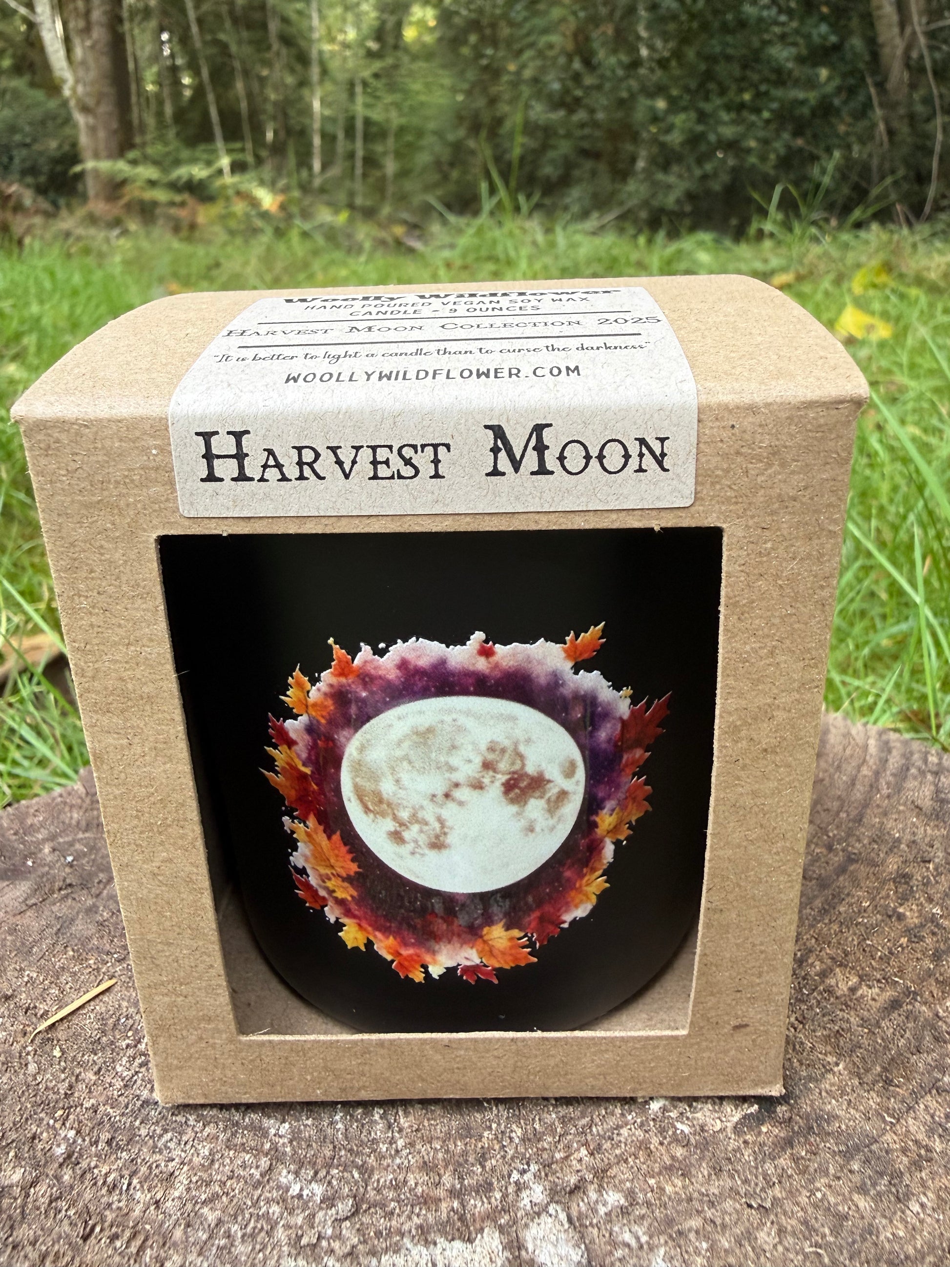 candle with 'Harvest Moon' design in a cardboard box outdoors