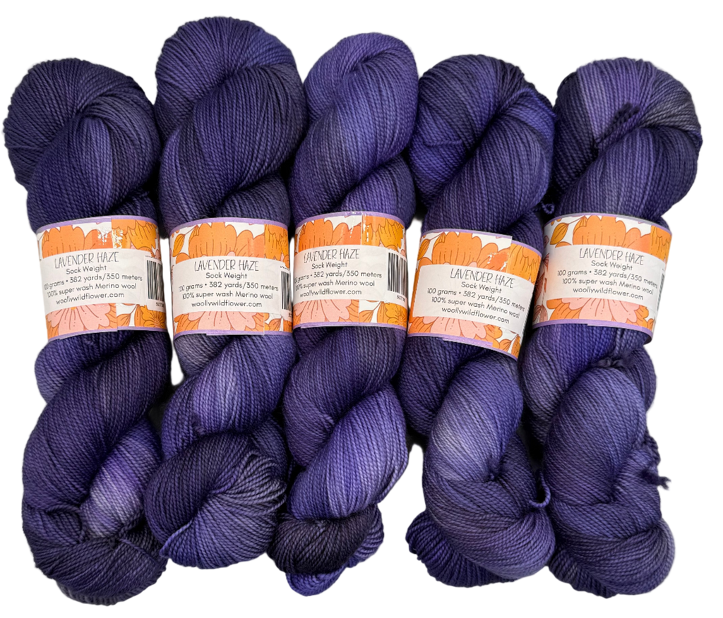 Five skeins of purple yarn with labels on a light gray background