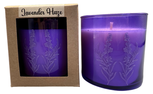 Purple candle with lavender design in packaging labeled 'Lavender Haze' on a gray background