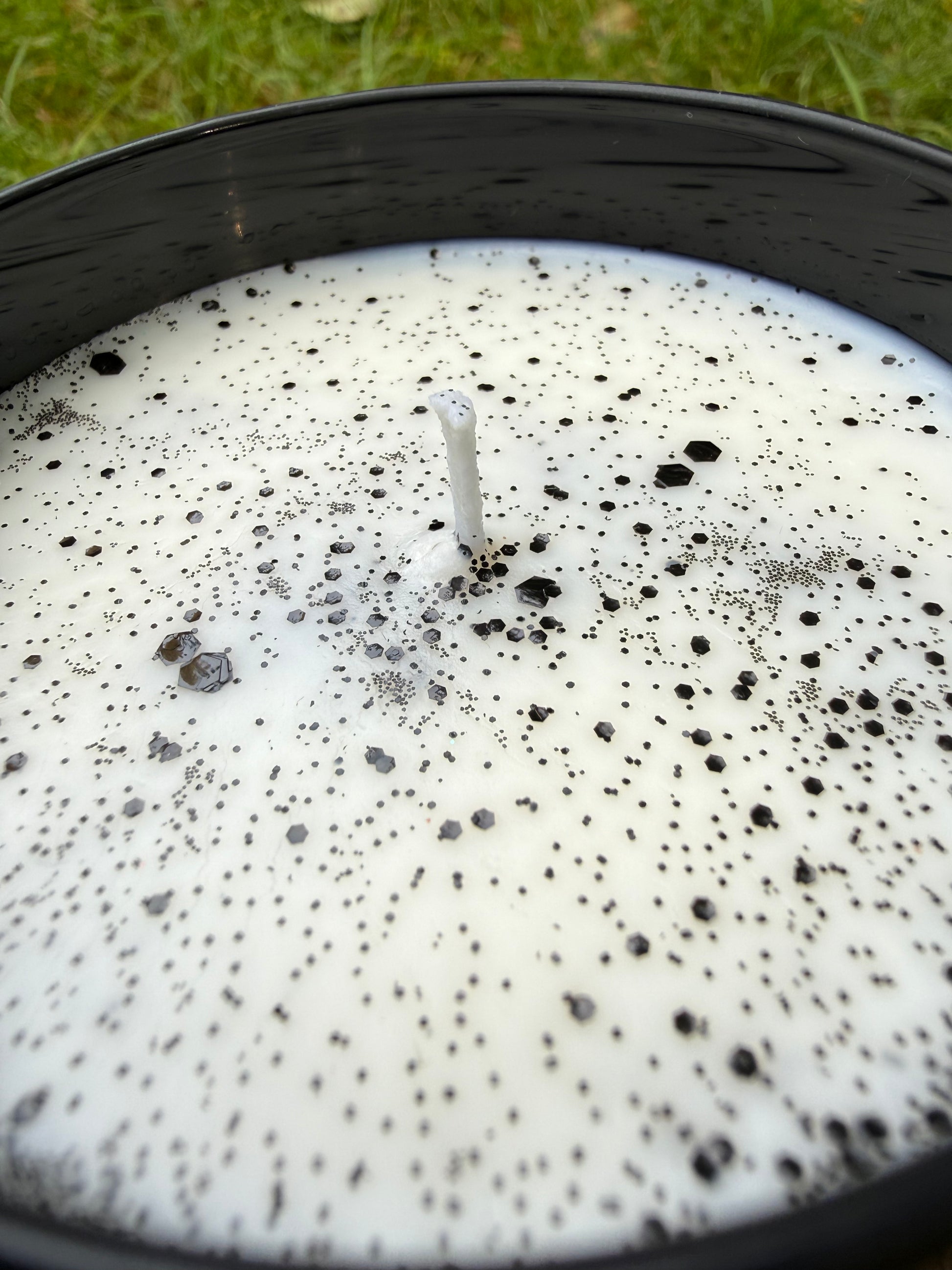 Close-up of a candle with black specks on a white background