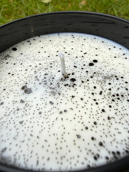 Close-up of a candle with black specks on a white background