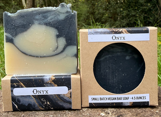 Onyx soap bar and packaging on a wooden surface with a forest background