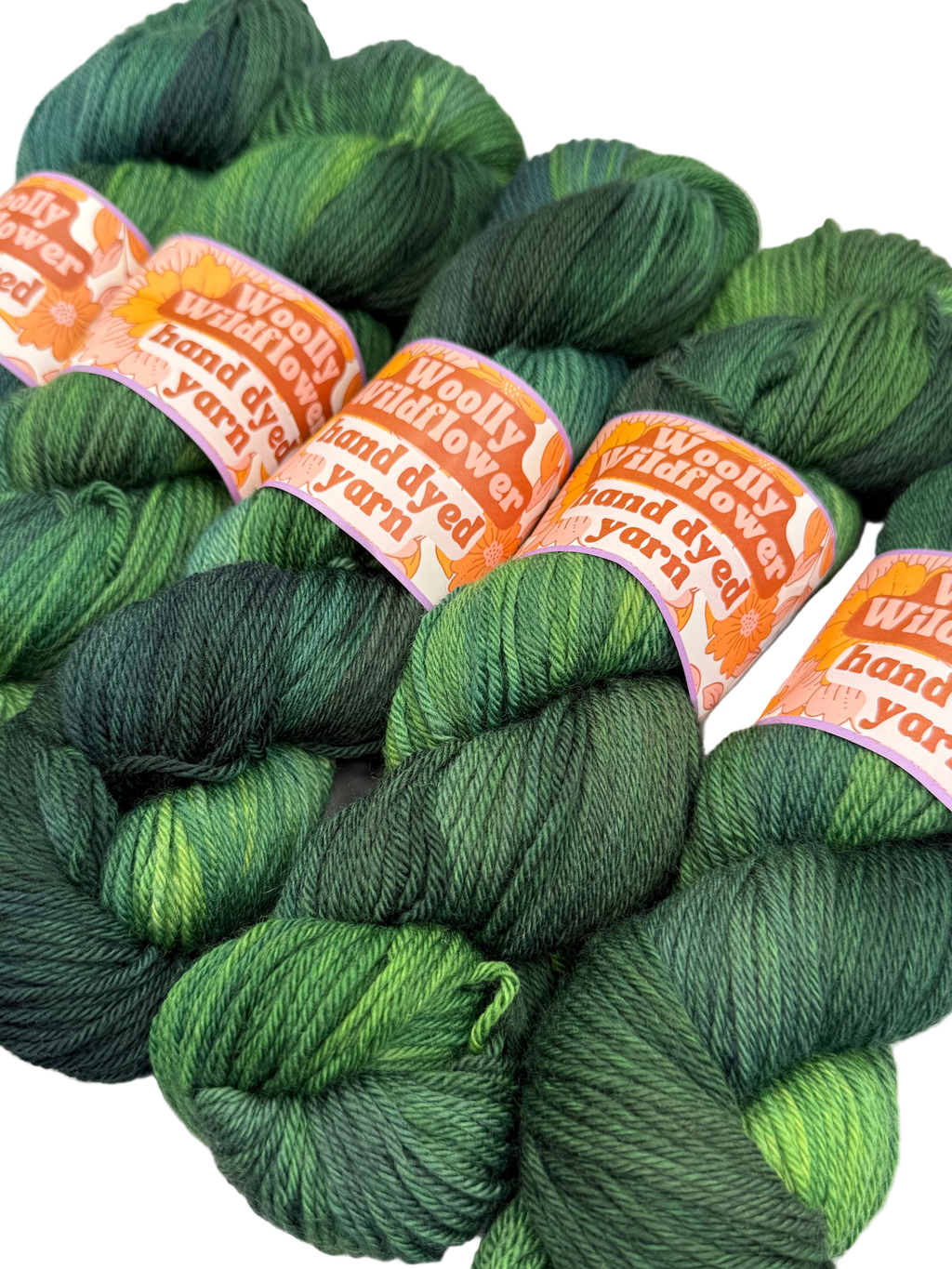 Green yarn skeins with orange labels on a white background