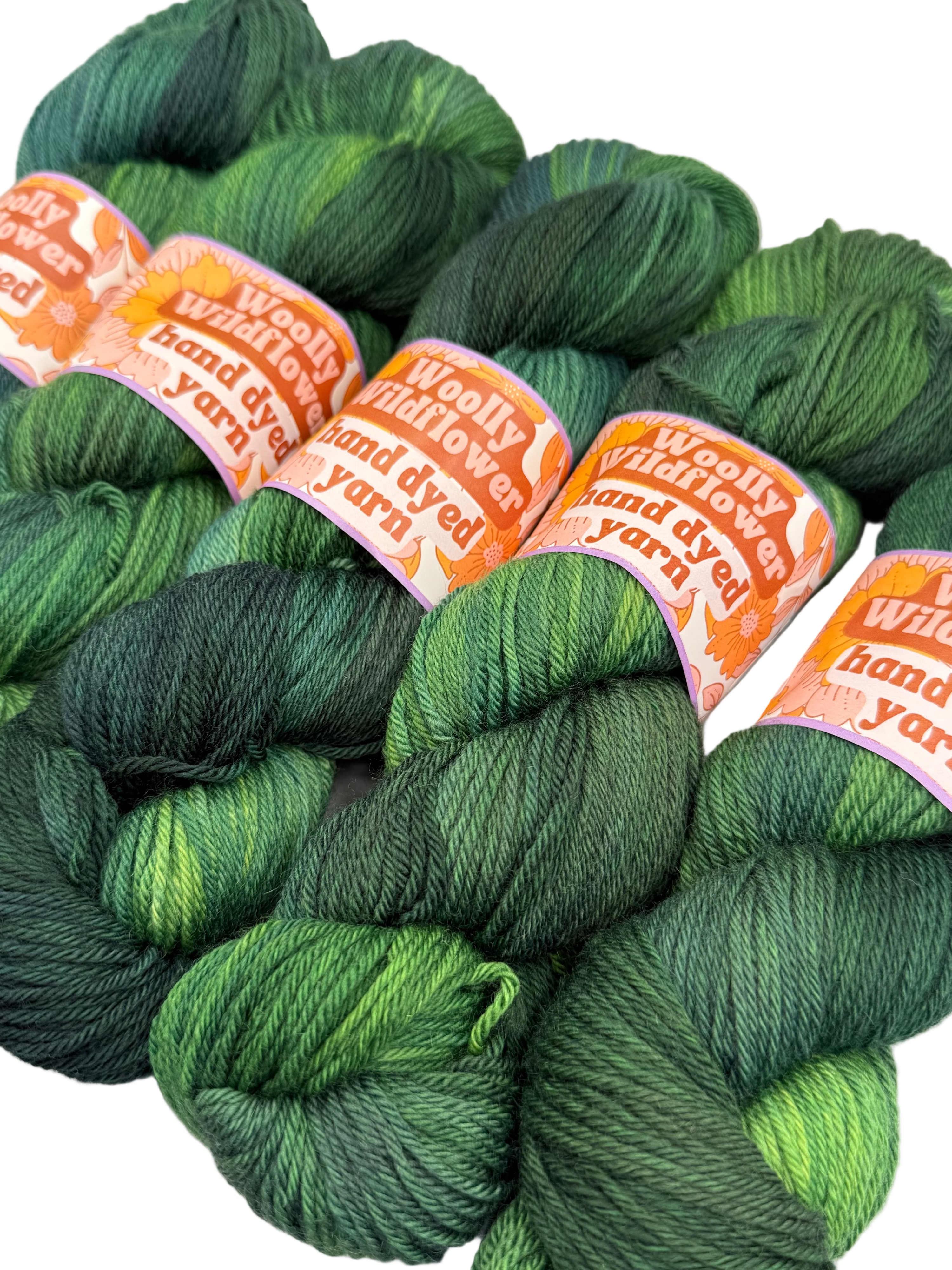 Green yarn skeins with orange labels on a white background