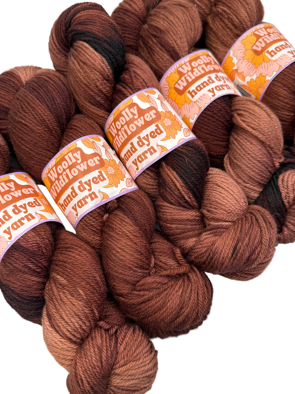 Brown yarn skeins with 'Woolly Wildflower' labels on a white background