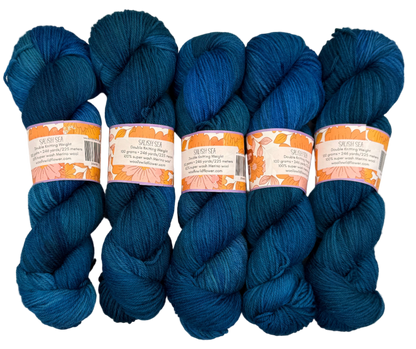Five skeins of blue yarn with labels on a light gray background