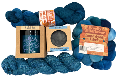 Blue yarn skeins with packaging and labels on a light gray background