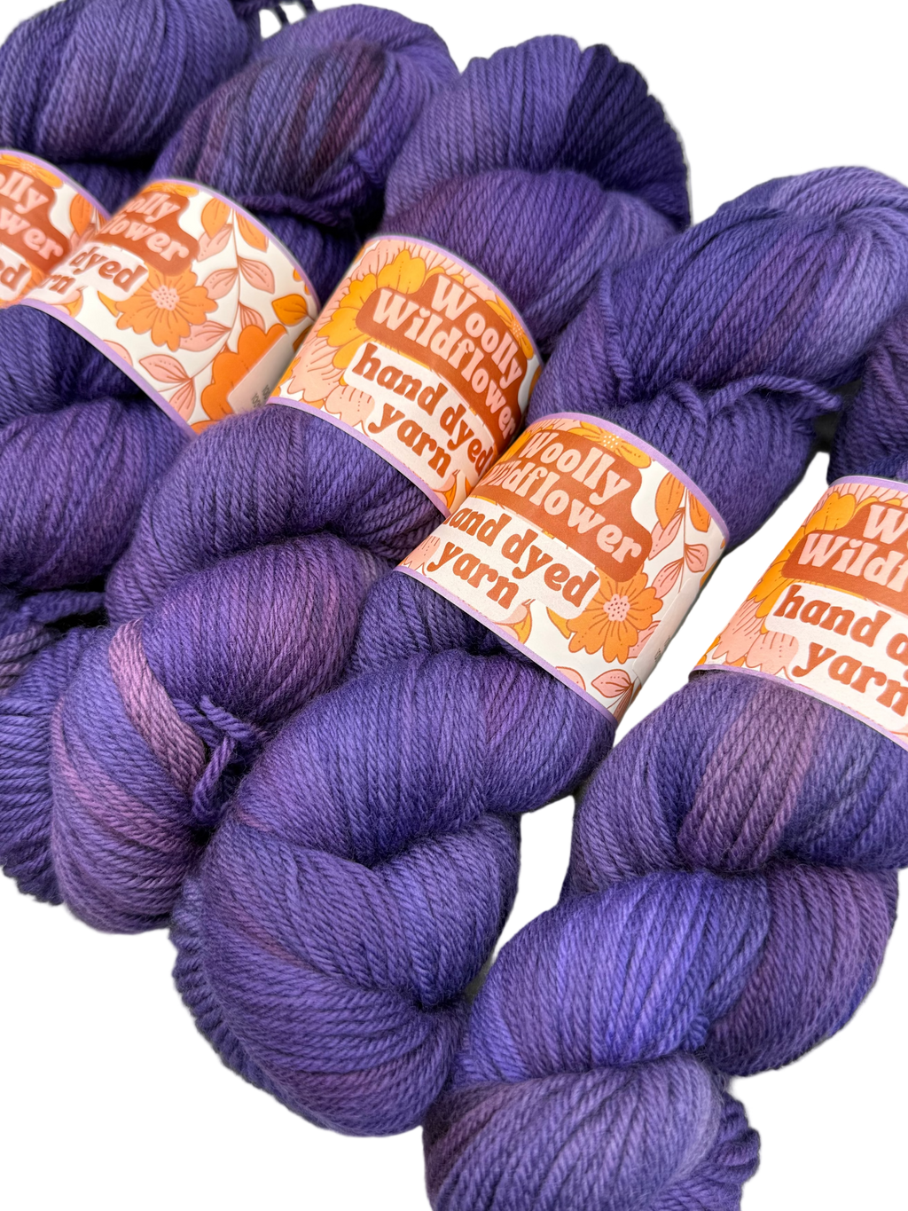 Purple yarn skeins with 'Woolly Flower' labels on a white background