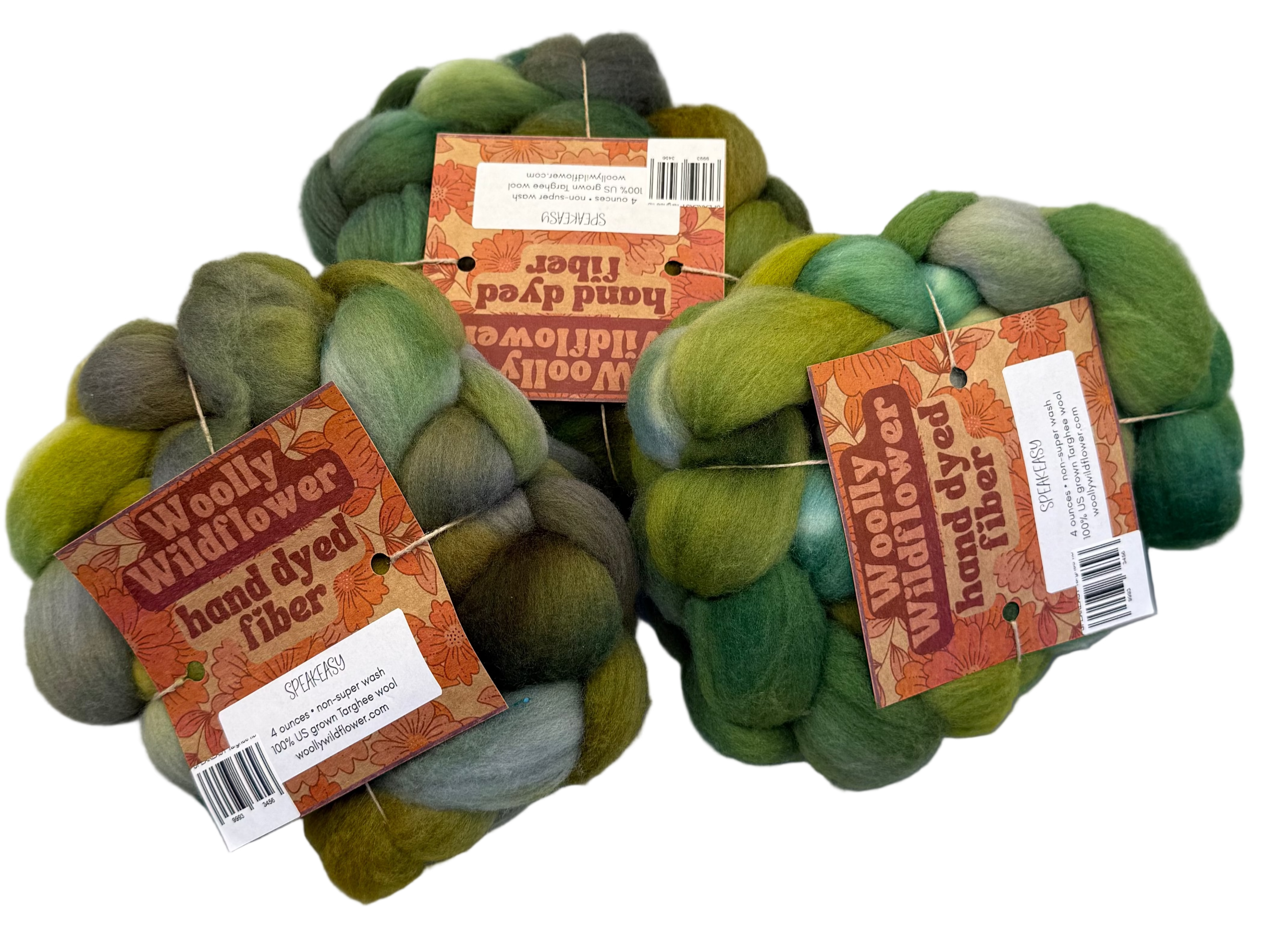 Three skeins of green hand-dyed fiber with labels on a gray background